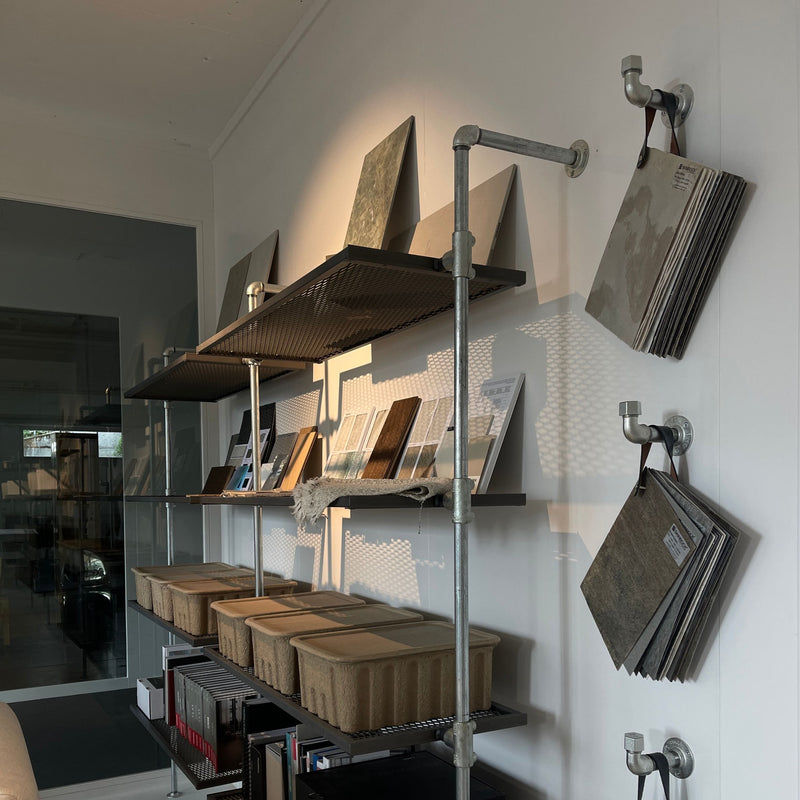 Krog i silver rør til ophæng af kataloger og materialefolder i showroom