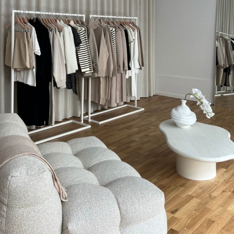 Simpelt tøjstativ lavet af hvide jernrør til showroomet eller butikken